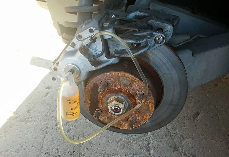Fresh brake fluid being flushed through a vehicle during mobile service in San Antonio