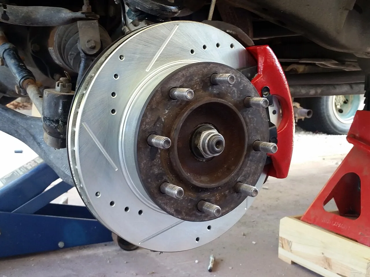 Technician inspecting a vehicle brake system during a mobile visit in San Antonio