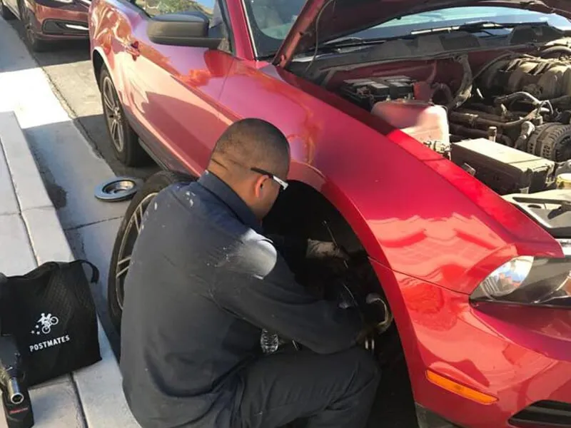 Mobile brake repair technician servicing a vehicle in a driveway in San Antonio